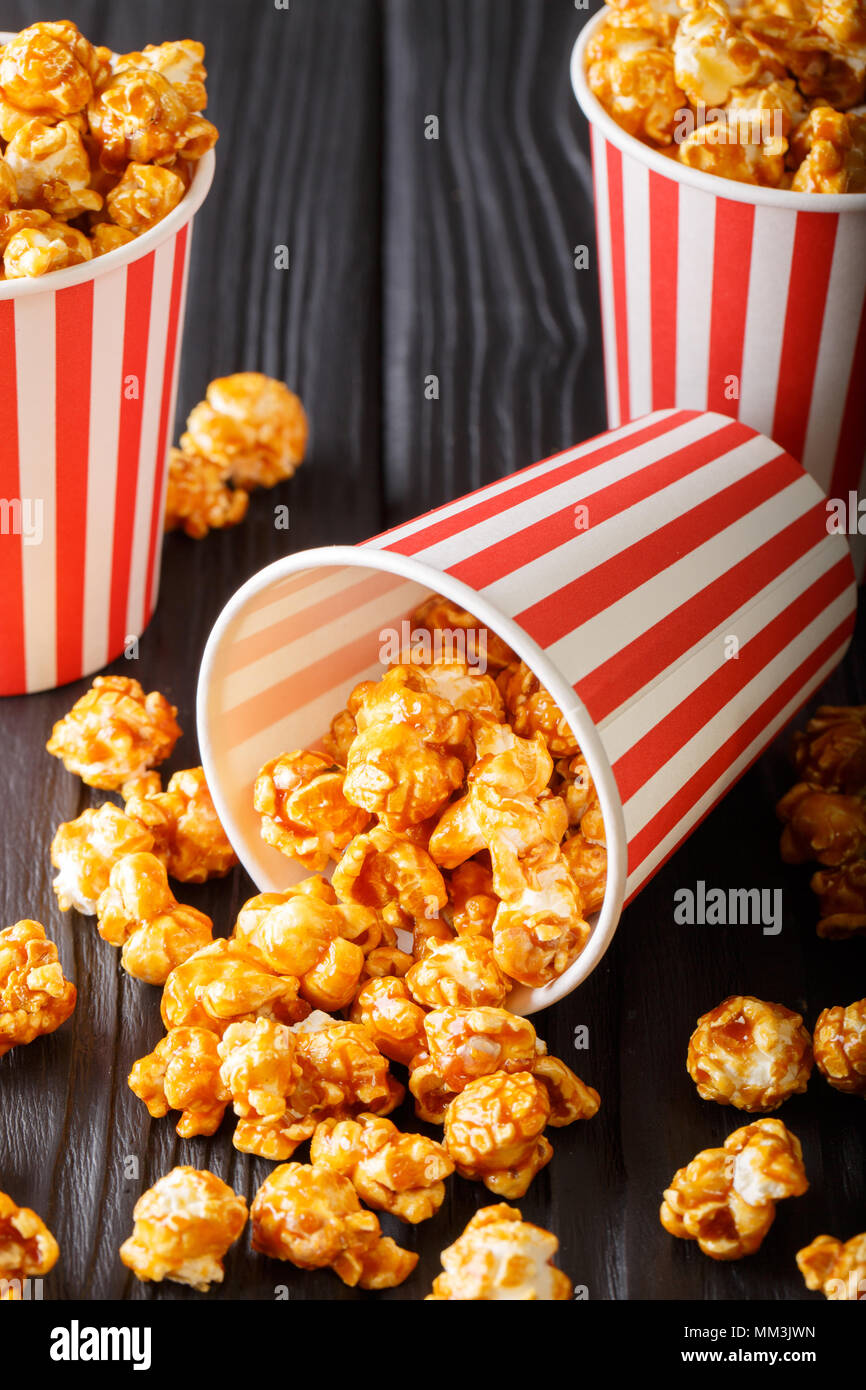 Dolce caramello popcorn in bicchieri di carta di close-up sulla tavola nera  verticale Foto stock - Alamy