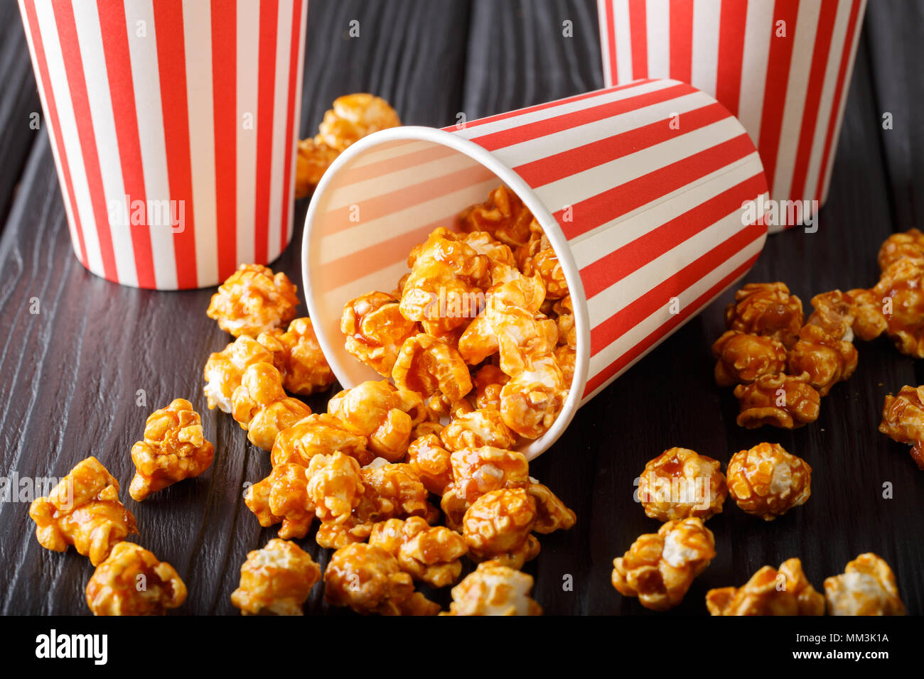 Deliziosi popcorn al caramello in bicchieri di carta vicino sul tavolo  orizzontale Foto stock - Alamy