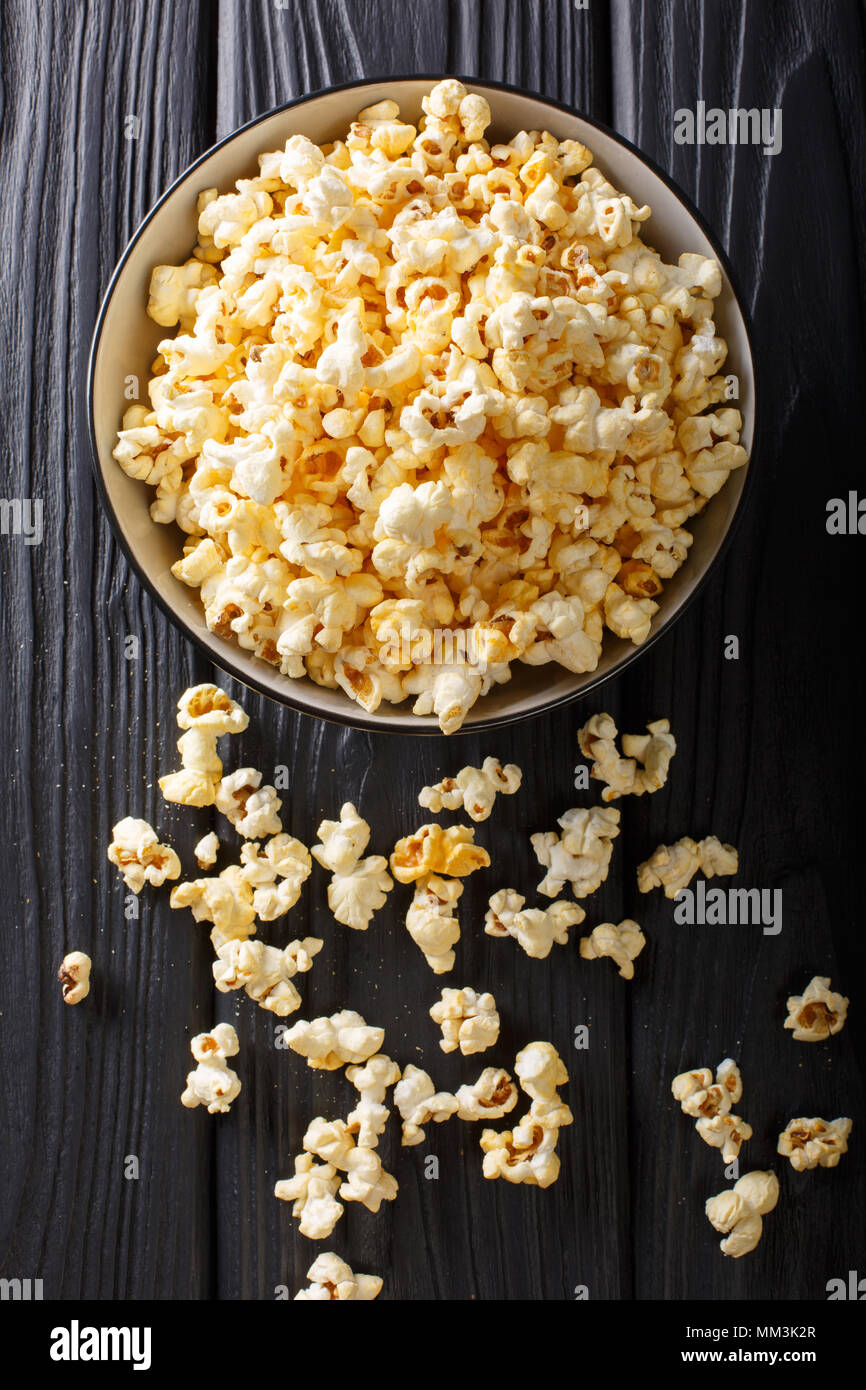 Il popcorn formaggio in una ciotola closeup su un tavolo. Verticale in alto vista da sopra Foto Stock