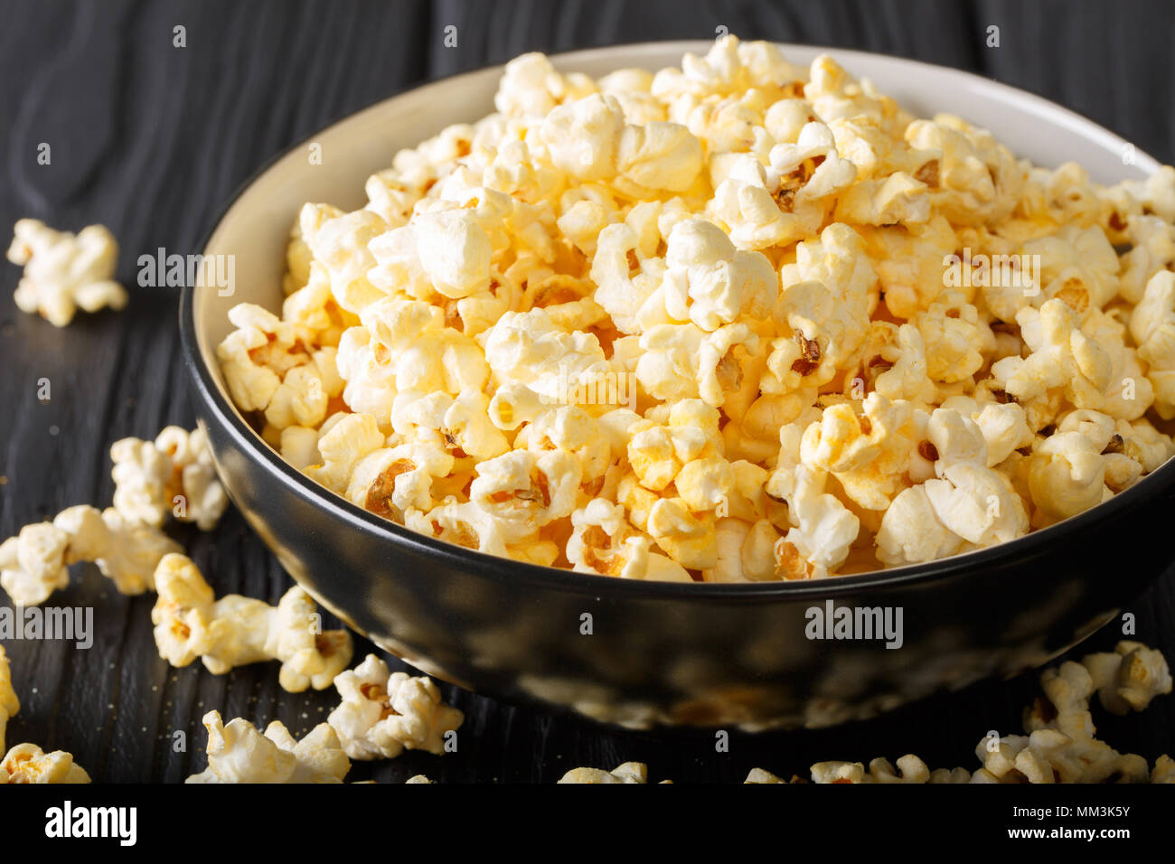 Popolari: snack salati popcorn con il formaggio Cheddar e il parmigiano in una ciotola vicino sul tavolo orizzontale. Foto Stock