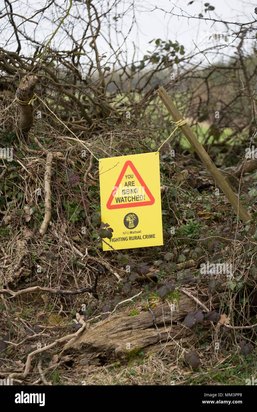 Un segnale di avvertimento a fianco di terreni agricoli volta a scoraggiare la criminalità nelle aree rurali. A nord del Dorset England Regno Unito. Foto Stock