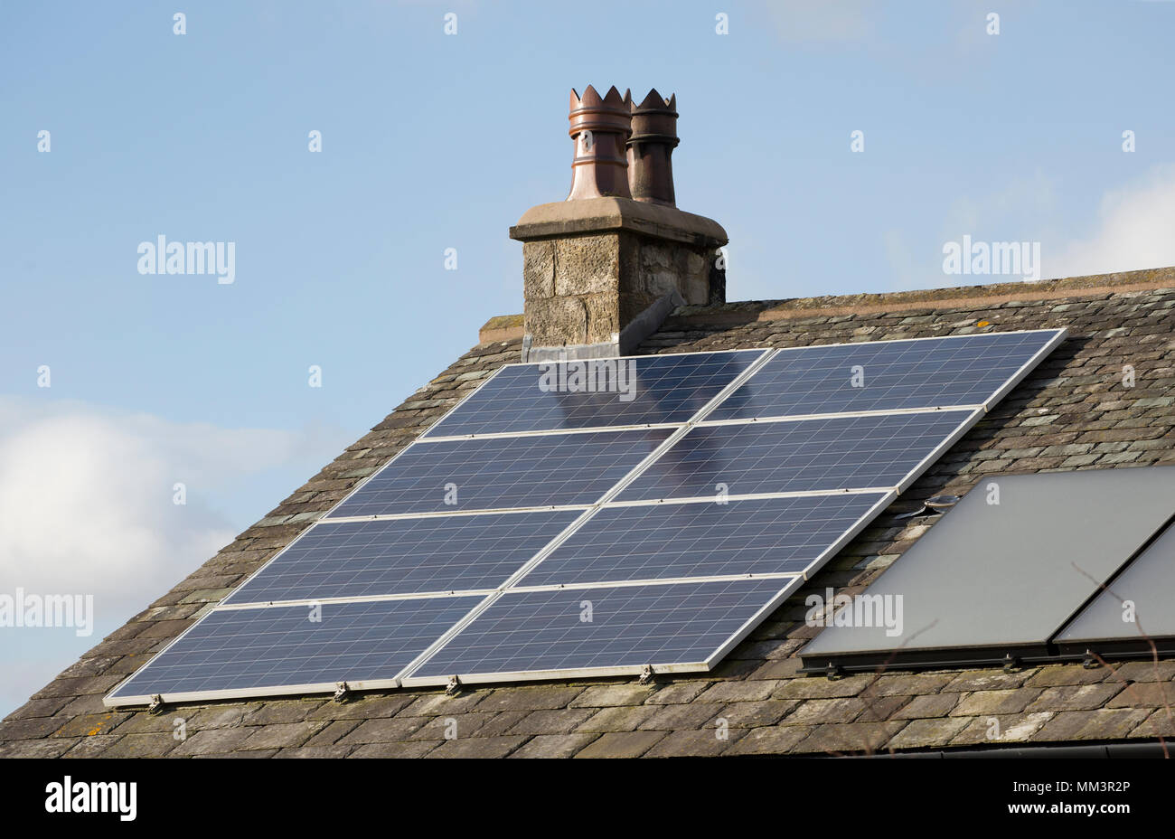 Pannelli solari sul tetto di una casa accanto al camino tradizionale pots. Nord Inghilterra Dorset Regno Unito Foto Stock