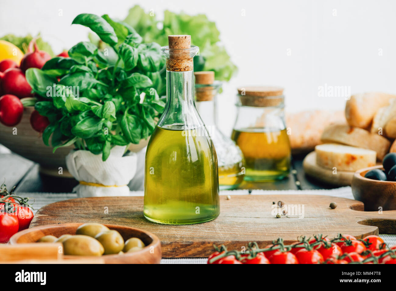 Olio di oliva bottiglie con verdure Foto Stock