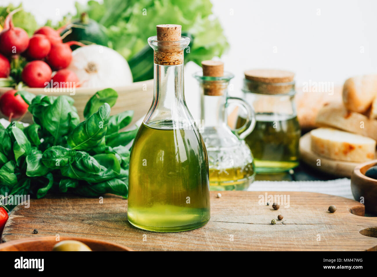 Olio di oliva bottiglie con verdure Foto Stock