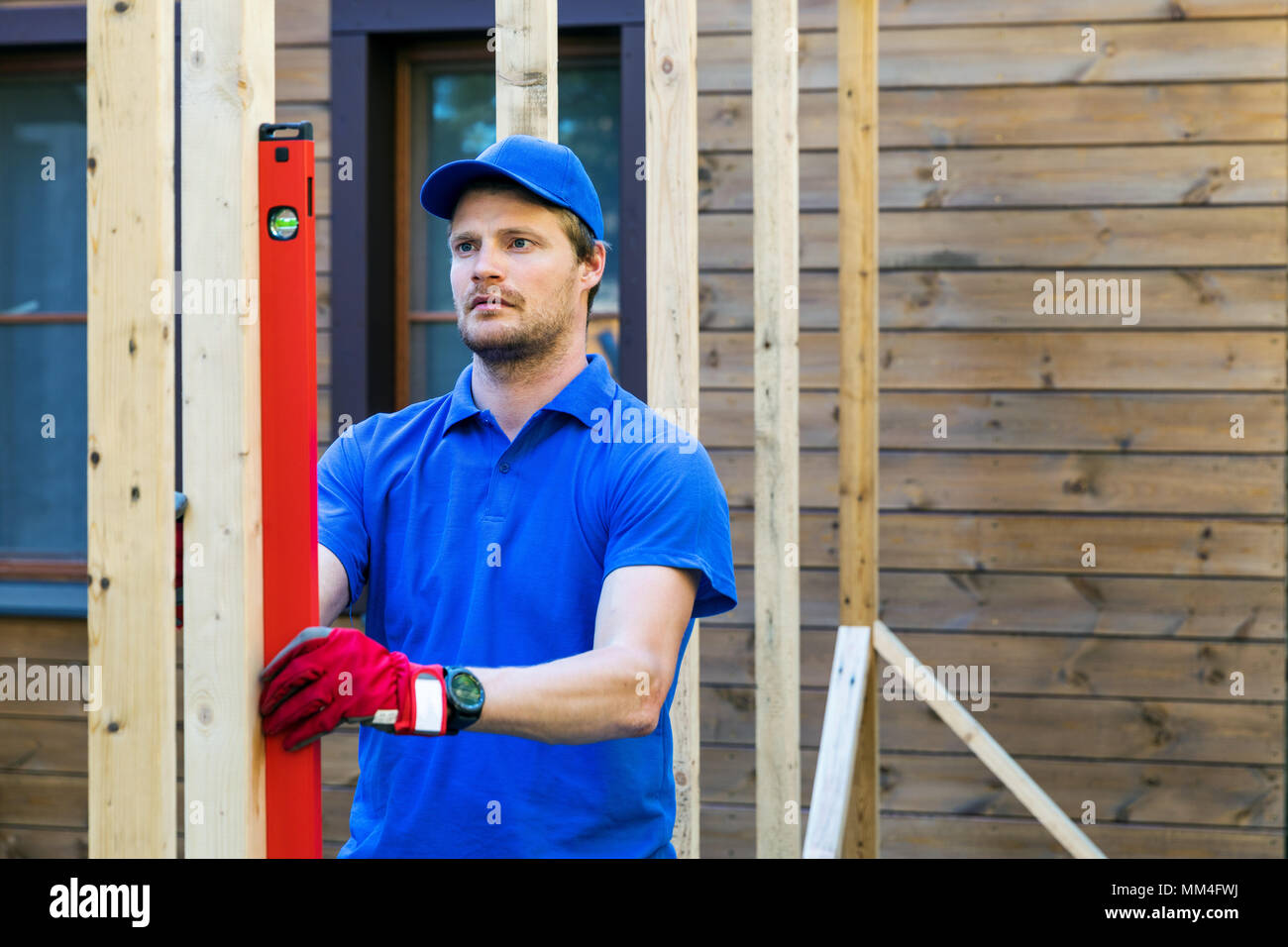 Lavoratore verificare il livello di casa in legno struttura Foto Stock