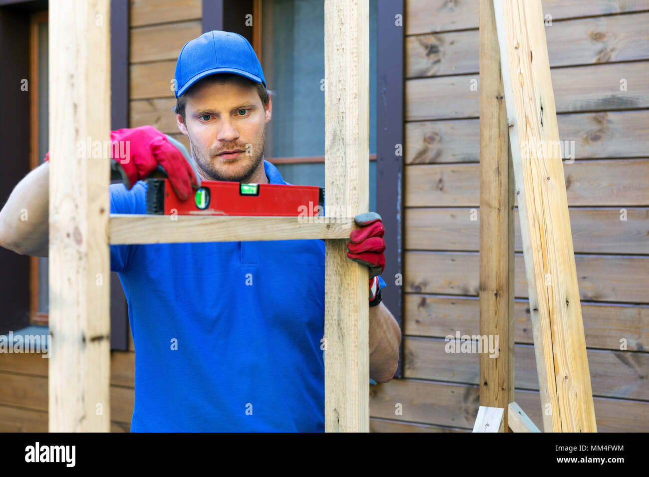 Operaio edile di controllare il livello del telaio in legno Foto Stock