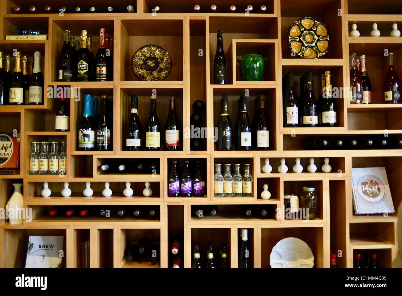 Elegante parete in legno Scaffali la visualizzazione di vini pregiati, articoli da regalo, piastre e libri di cucina per la vendita, La Bergerie, mercato artigianale, Fredericksburg, Texas, Stati Uniti d'America Foto Stock