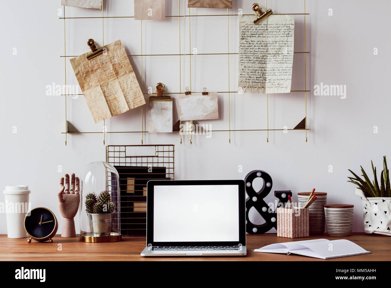 Laptop, cactus, decorazioni e portatile su una scrivania in legno e una  parete metallica organizzatore al di sopra di esso Foto stock - Alamy
