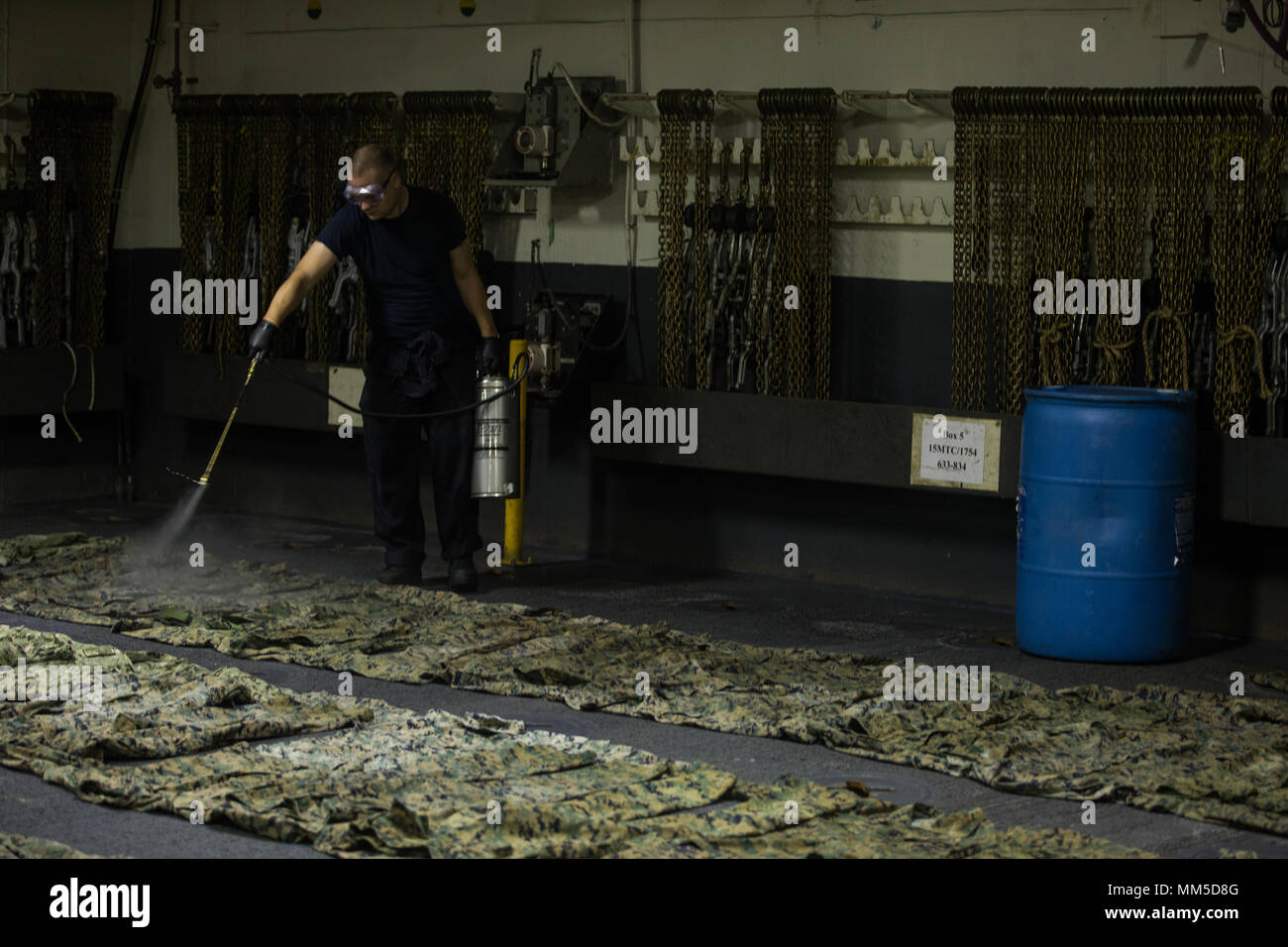 Un U.S. Navy Sailor spray repellente per insetti NEGLI STATI UNITI. Marine Corps woodland uniformi di utilità a bordo della USS Iwo Jima (LHD 7), Sett. 10, 2017. Il repellente per insetti è stata applicata a Marines' uniformi di utility per la protezione contro gli insetti come i Marines preparare a fornire del Dipartimento della Difesa a supporto della Federal Emergency Management Agency, statali e locali agli sforzi di risposta dopo il passaggio dell uragano Irma. (U.S. Marine Corps foto di Cpl. Ieter T. pietra) Foto Stock