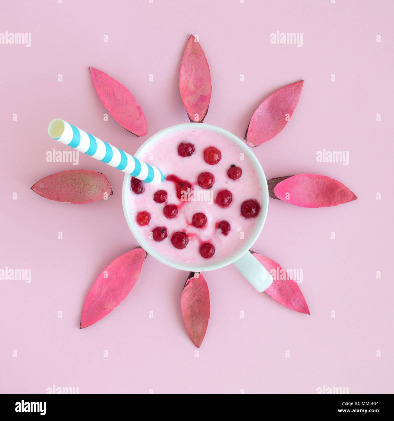 Piatto di laici smoothie con ribes rosso bacche, cannuccia e petali a forma di fiore contro di rosa pastello minima di sfondo concetto creativo. Foto Stock