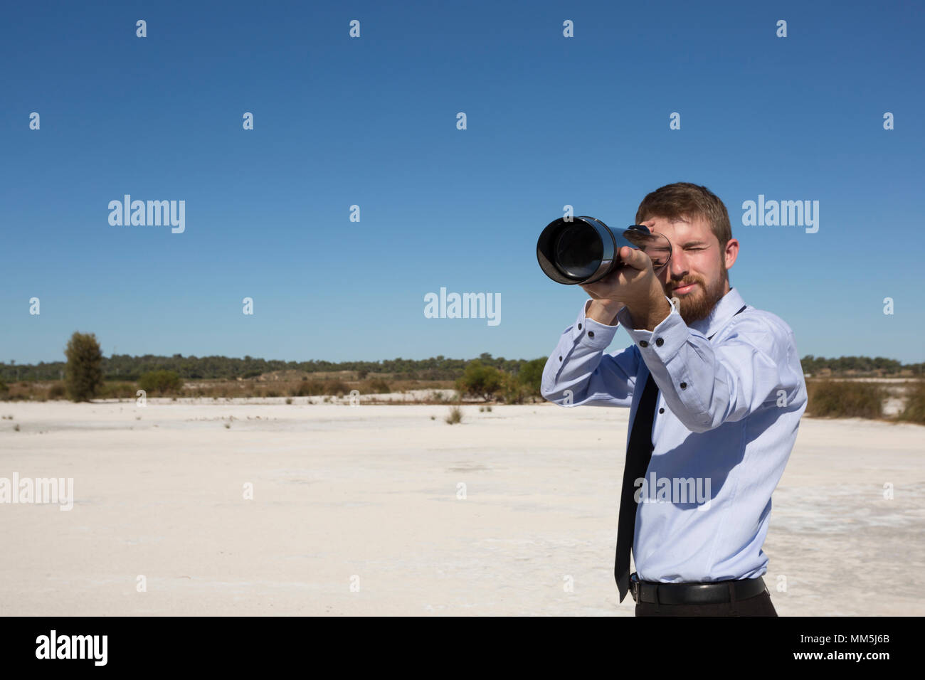 Un giovane uomo di affari di guardare attraverso un telescopio. Business concpets. Foto Stock