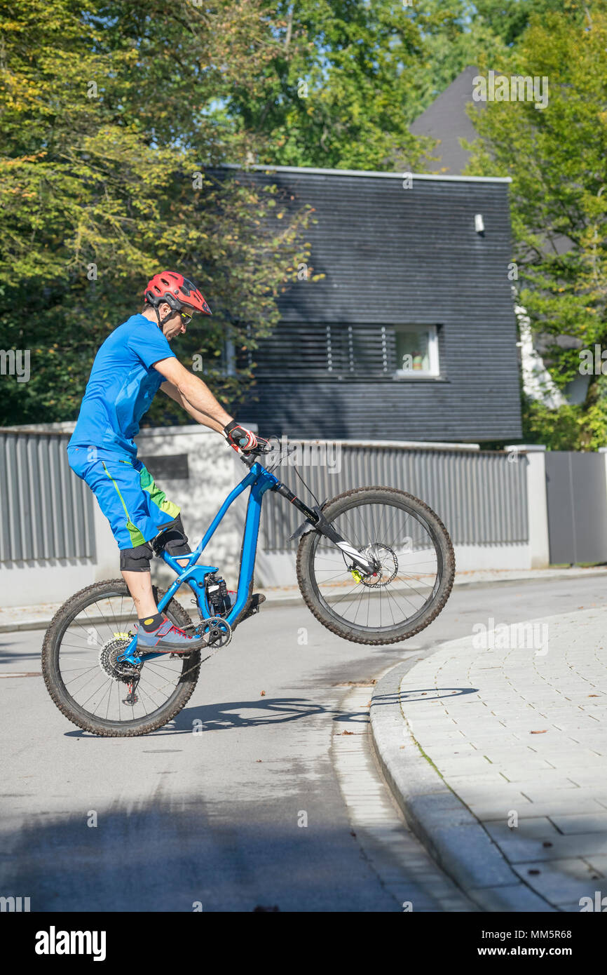L'uomo facendo un'impennata con la mountain bike, Baviera, Germania Foto Stock