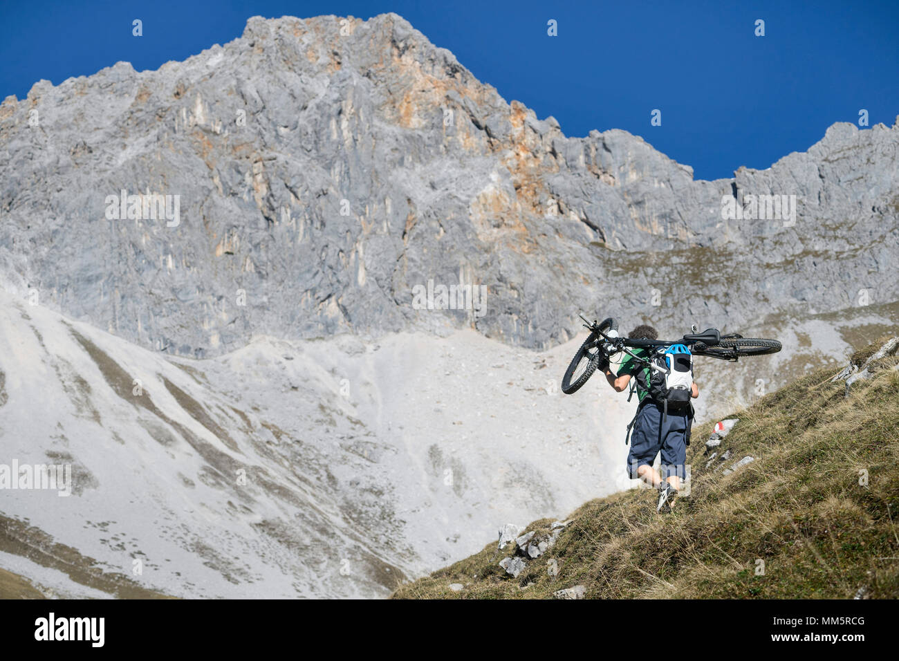 Mountain bike bicicletta che porta sulle sue spalle, Tirolo, Austria Foto Stock