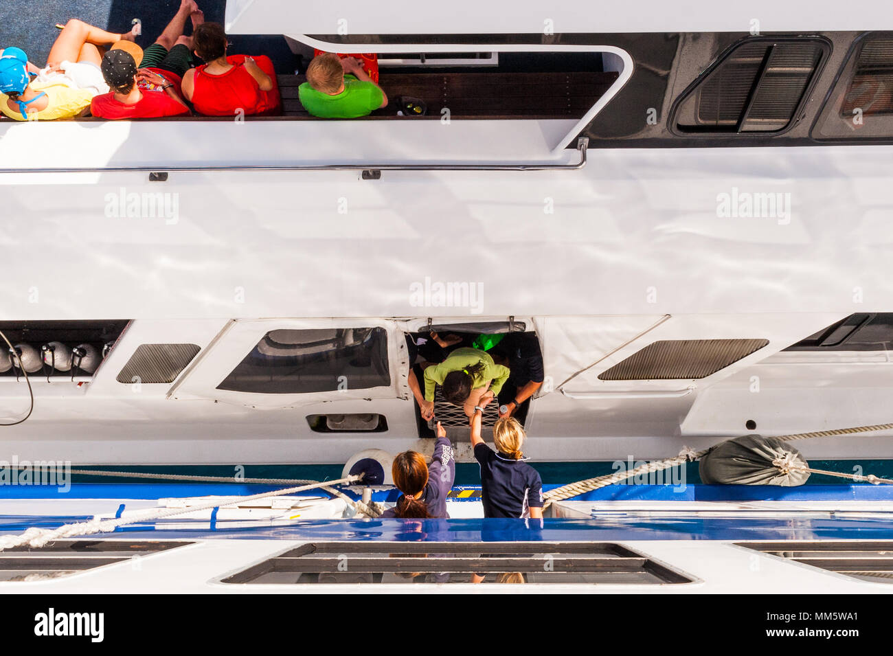I passeggeri e i materiali di consumo sono trasferiti da una barca per un'altra metà ocean sopra la Grande Barriera Corallina del Queensland, Australia. Foto Stock