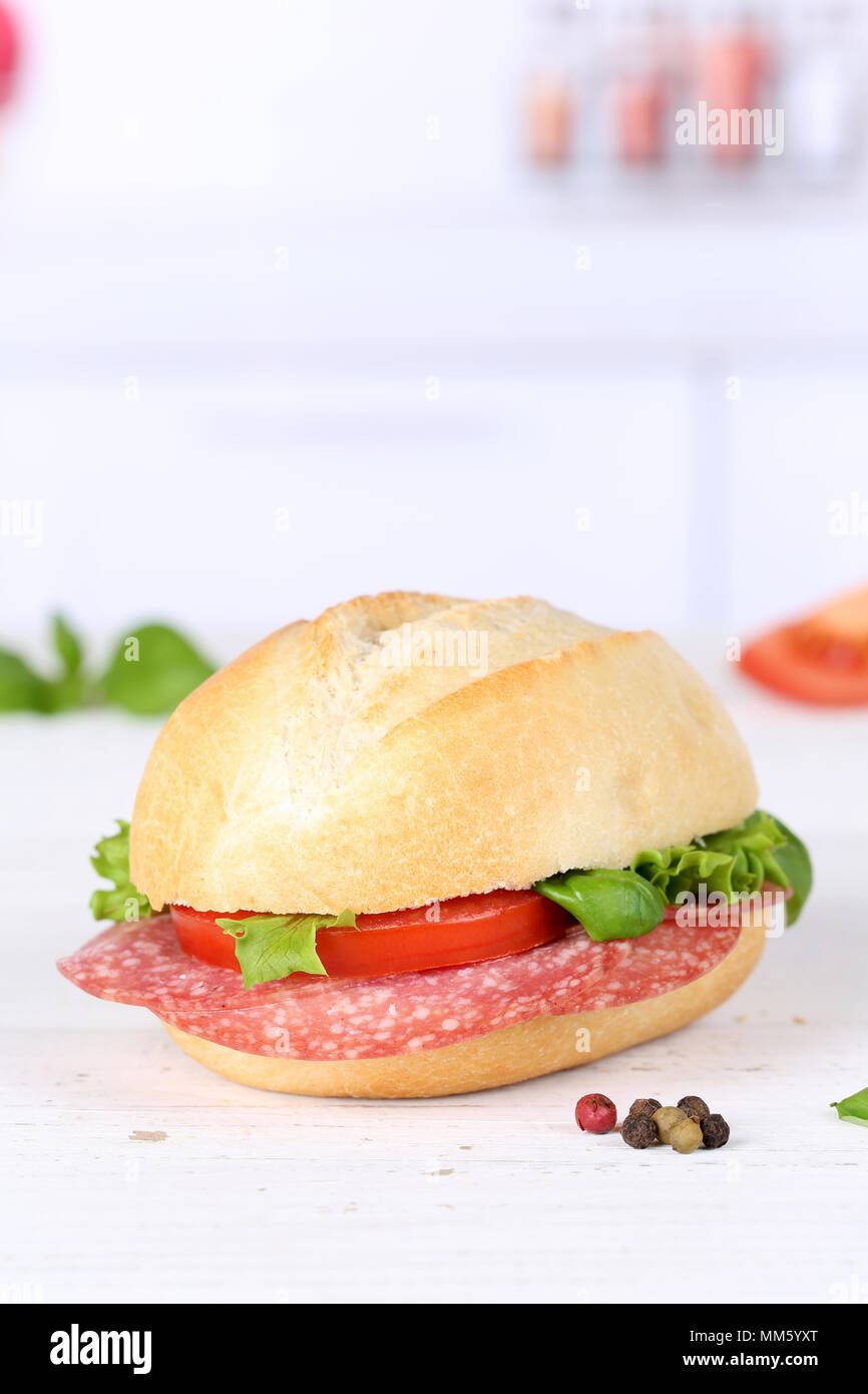 Baguette sandwich con salame prosciutto copyspace formato ritratto su tavola di legno legno Foto Stock