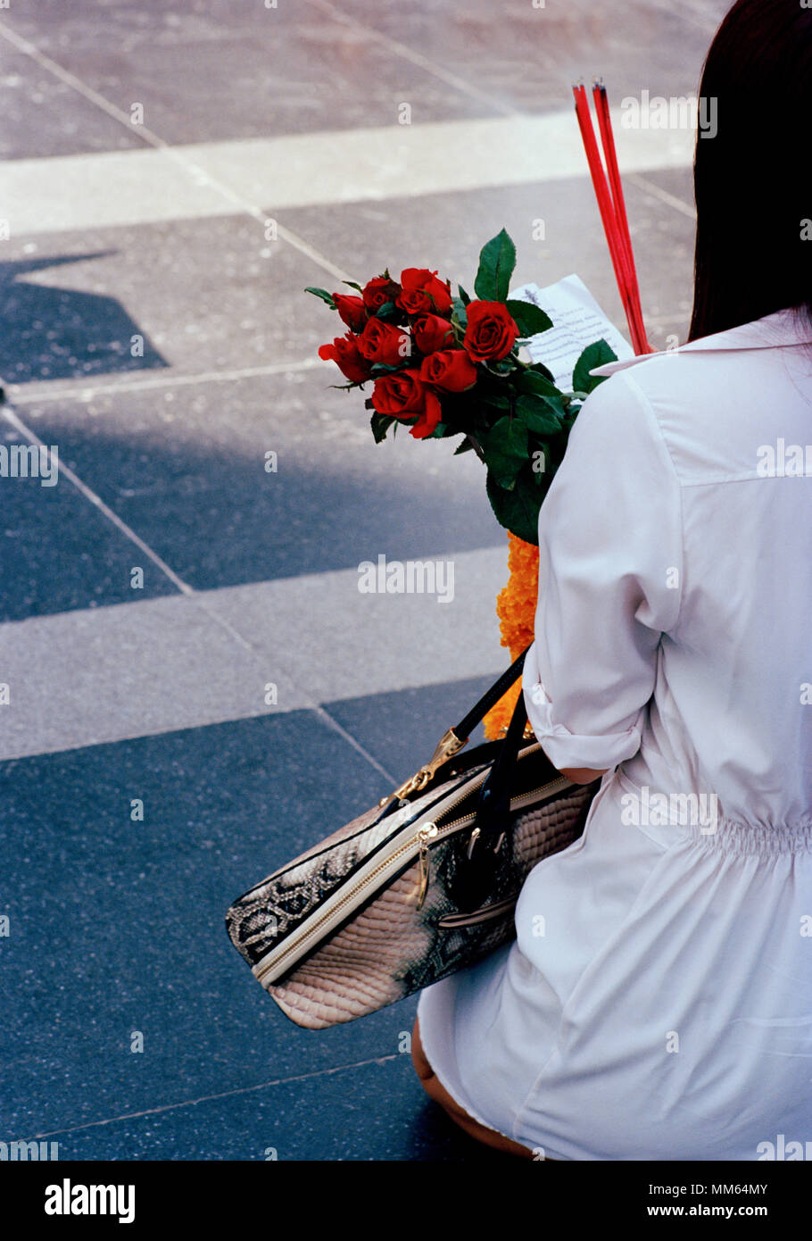 Donna con pellegrino offerte presso la statua di Trimurti Dio dell amore al mondo centrale di Bangkok in Thailandia nel sud-est asiatico in Estremo Oriente. Reportage di Viaggio Foto Stock