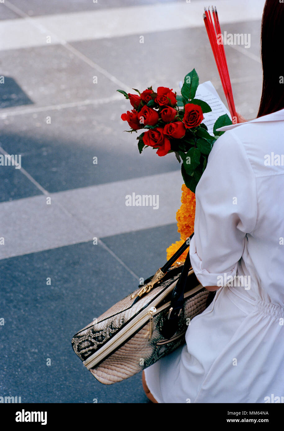 Donna con pellegrino offerte presso la statua di Trimurti Dio dell amore al mondo centrale di Bangkok in Thailandia nel sud-est asiatico in Estremo Oriente. Reportage di Viaggio Foto Stock