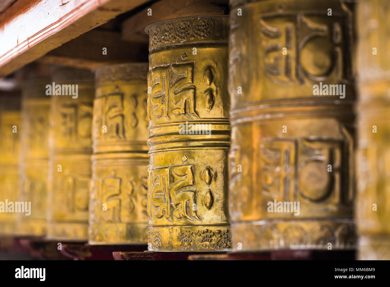 Buddista Tibetana pregando ruote in Ladakh, India. Tradizionalmente il mantra Om mani padme Hum è scritto in sanscrito sulla parte esterna della ruota Foto Stock