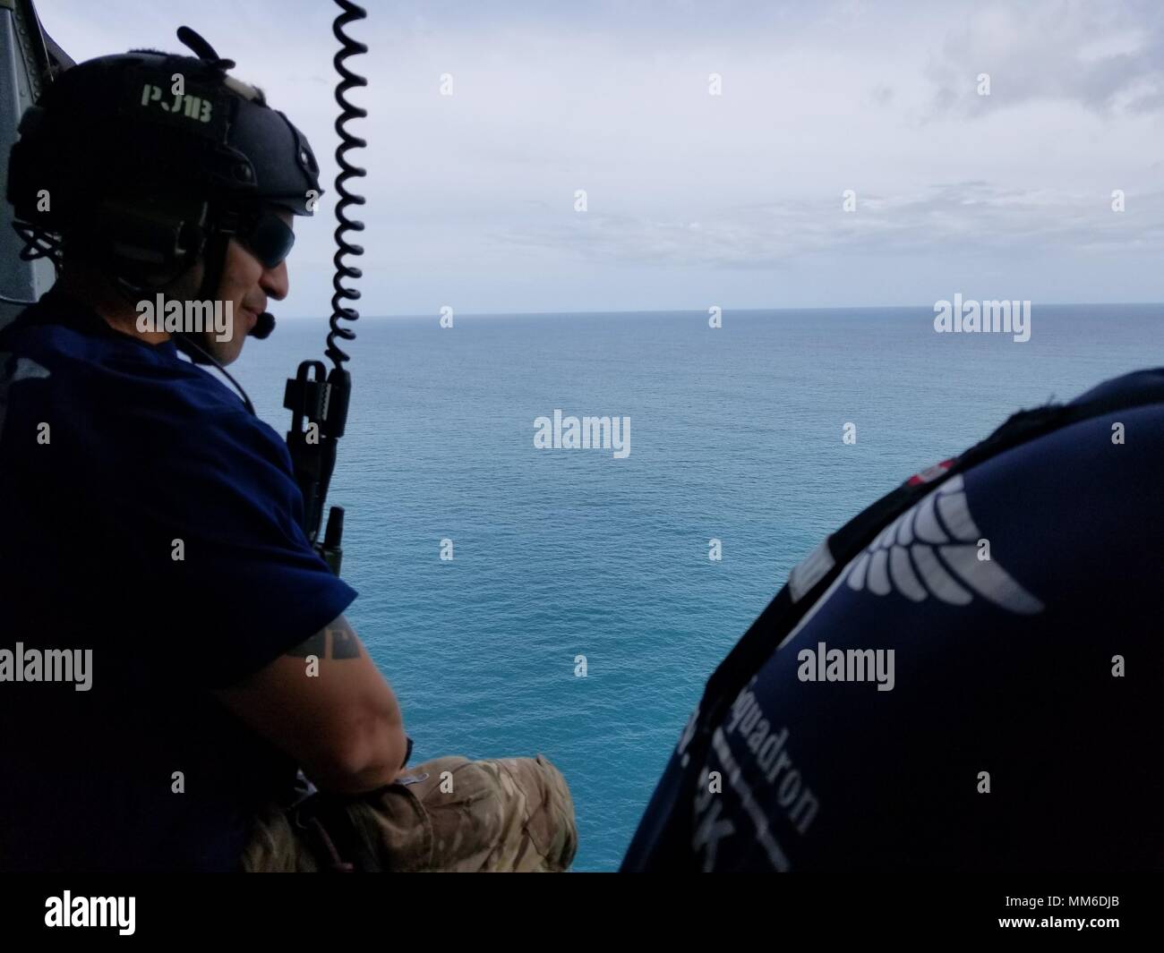 Pararescuemen guardare fuori alla vista da sopra l'acqua sul loro modo di san Tommaso. Avieri dal New York Air National Guard la 106ª Ala di soccorso vola su san Tommaso e San Giovanni in un HH-60 Pave Hawk elicottero il 10 settembre, 2017. Essi sono alla ricerca di persone in stato di bisogno di assistenza critica dopo il passaggio dell uragano Irma. Foto Stock