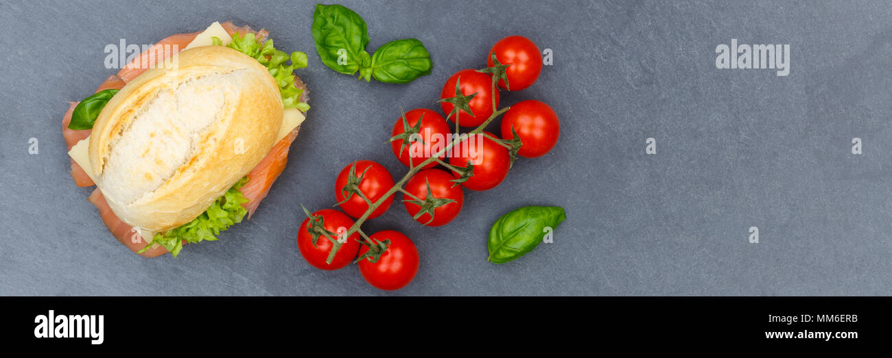 Baguette sandwich con salmone affumicato pesce dal banner sopra ardesia vista superiore Foto Stock