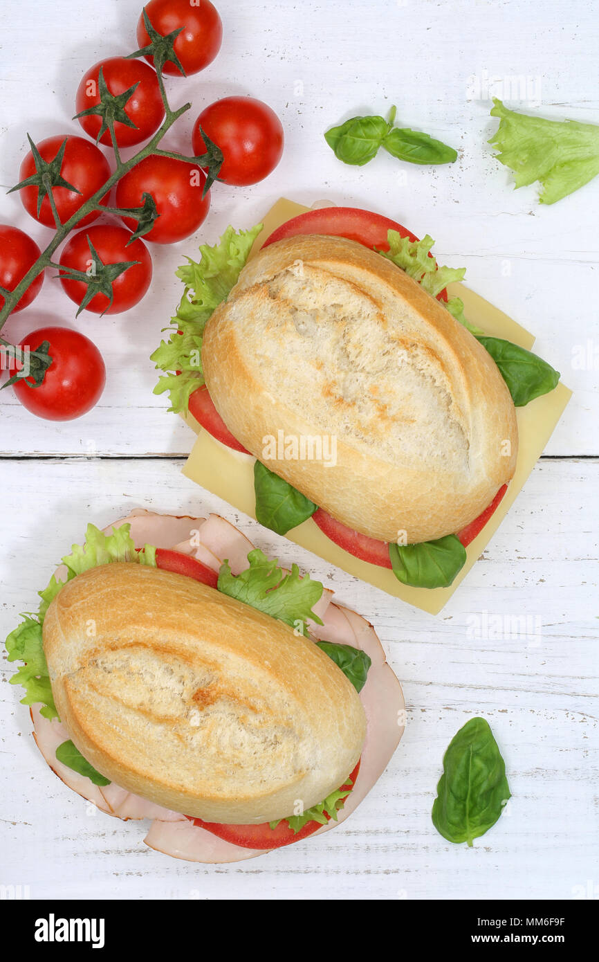 Panino baguette con prosciutto e formaggio da sopra il formato ritratto su tavola di legno legno Foto Stock