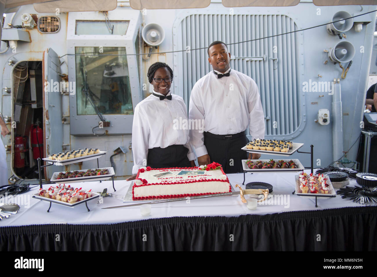 170909-N-HB733-084 NEW LONDON, conn. (Sett. 9, 2017) specialista culinaria marinaio Loreal Ford, sinistra e specialista culinaria 2a classe Stetson Varner servire dessert a bordo guidato-missile destroyer USS Cole (DDG 67) durante un ricevimento della Marina. Cole partecipa al Connecticut Maritime Heritage Festival che celebra lo stato del patrimonio marittimo e la storia. (U.S. Foto di Marina di Massa lo specialista di comunicazione di terza classe Brianna verde/rilasciato) Foto Stock