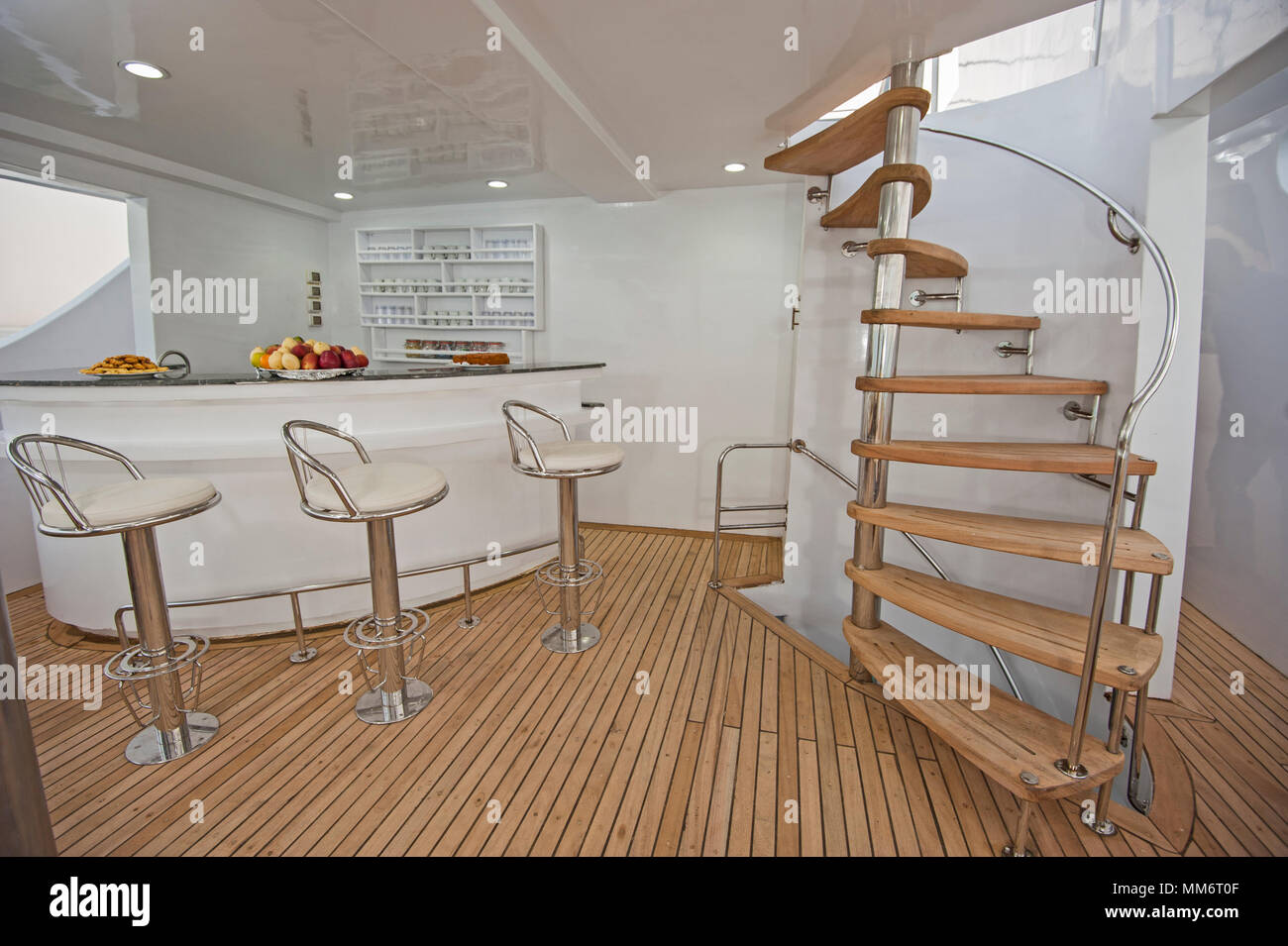 Curvi in legno scala a chiocciola e area bar sulla terrazza prendisole di grandi lussuoso yacht a motore Foto Stock