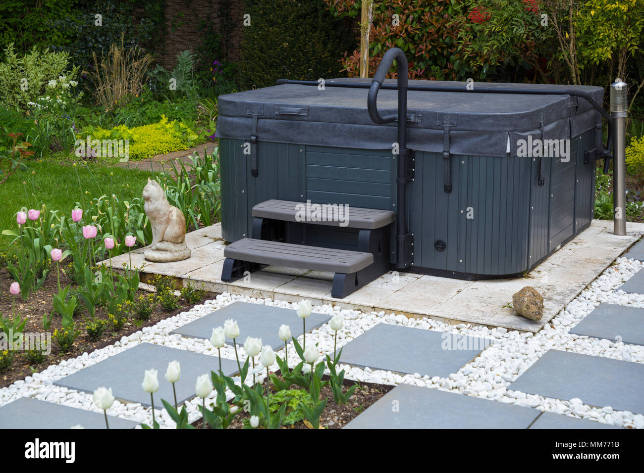 Symphony vetrificati di pavimentazione in lastre formano un percorso che conduce alla vasca idromassaggio. Credits: Design by Zinnia Garden Design. Costruzione per 4 paesaggi di vita Foto Stock