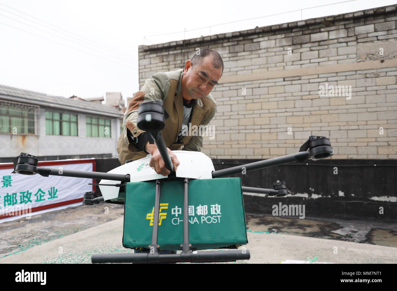 (180510) -- GUIYANG, 10 maggio 2018 (Xinhua) -- portalettere Wang Hua prepara un drone in corrispondenza di un ramo post office in Weicheng Township, Qingzhen città del sud-ovest della Cina di Guizhou, 10 maggio 2018. Fuchi stanno assumendo un ruolo crescente nel settore della logistica, specialmente nelle zone più remote della Cina. Recentemente, un ramo post office nella regione montuosa di Guizhou ha iniziato a fornire piccoli pacchetti con fuchi non presidiate. L'over-un-metro-wide drone con sei eliche, ha trasportato con successo i pacchi di peso non superiore a 5 kg, a cinque villaggi lontani. A causa di esso, una consegna utilizzato per un costo Foto Stock