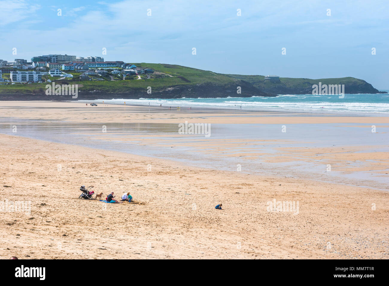 Una famiglia seduta su un vuoto Fistral Beach in Newquay Cornwall. Foto Stock