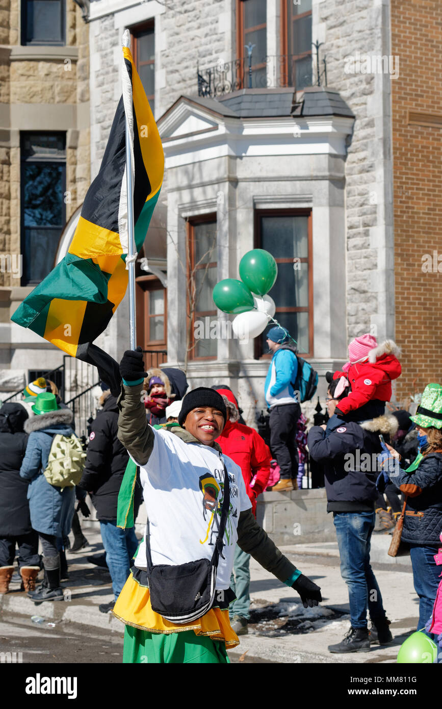 Una signora giamaicana sventola una bandiera giamaicana mi nil Montreal il giorno di San Patrizio parade Foto Stock