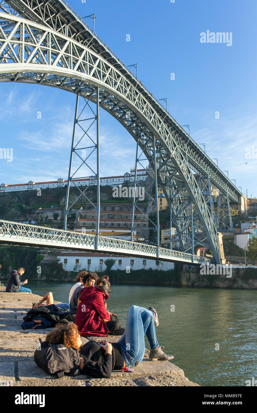 Porto, Portogallo - 19 Gennaio 2018: Unidentified giovani backpackers riposare sotto il famoso Ponte dom Luis a Porto, Portogallo Foto Stock