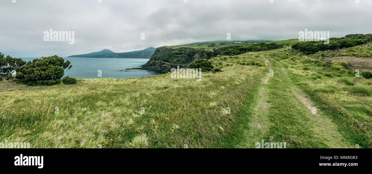 Vista panoramica con un percorso trail sull'erba a Morro do Castelo Branco, Faial, Azzorre. Foto Stock