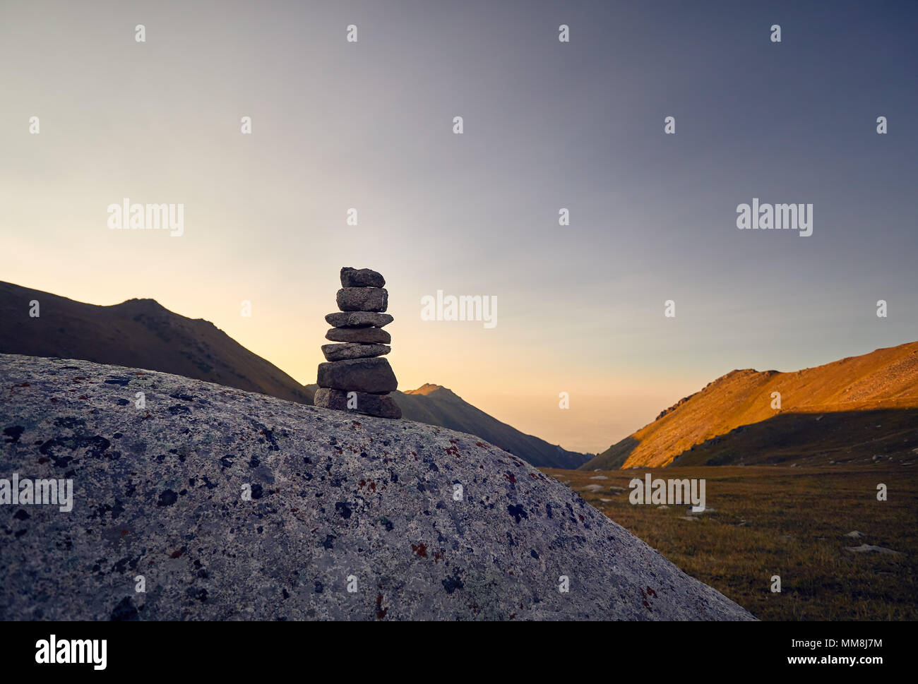 Mucchio di pietre in montagna in Cielo di tramonto sfondo in Kazakistan Foto Stock