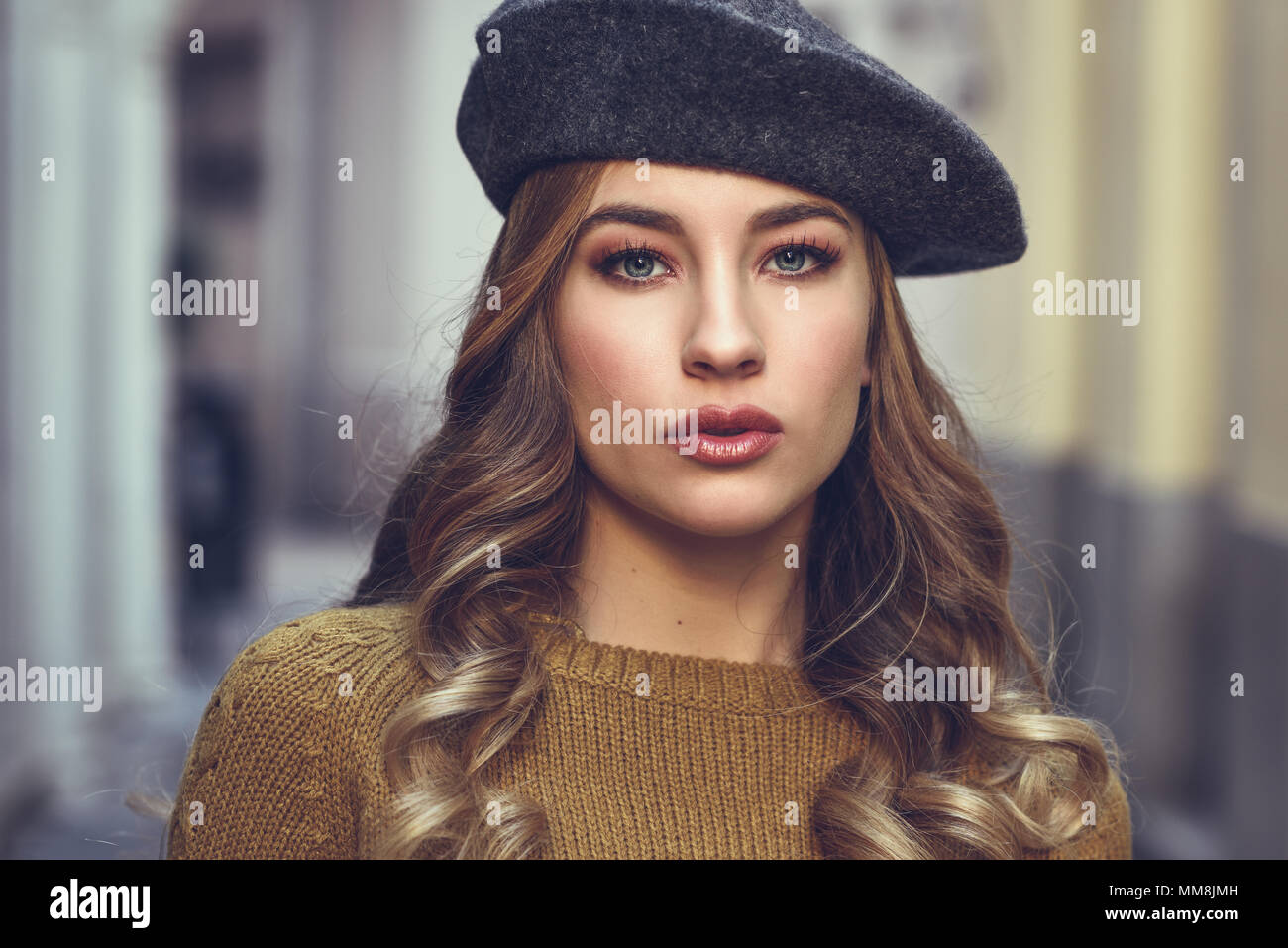 Bionda donna russa in background urbano. Bellissima fanciulla indossando beret, nero giacca di pelle e mini gonna in piedi in strada. Piuttosto femal Foto Stock