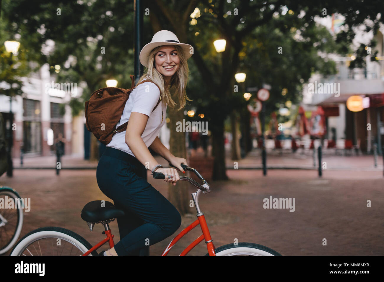 Attraente giovane donna in bicicletta in città. Femmina Bicicletta Equitazione. Foto Stock