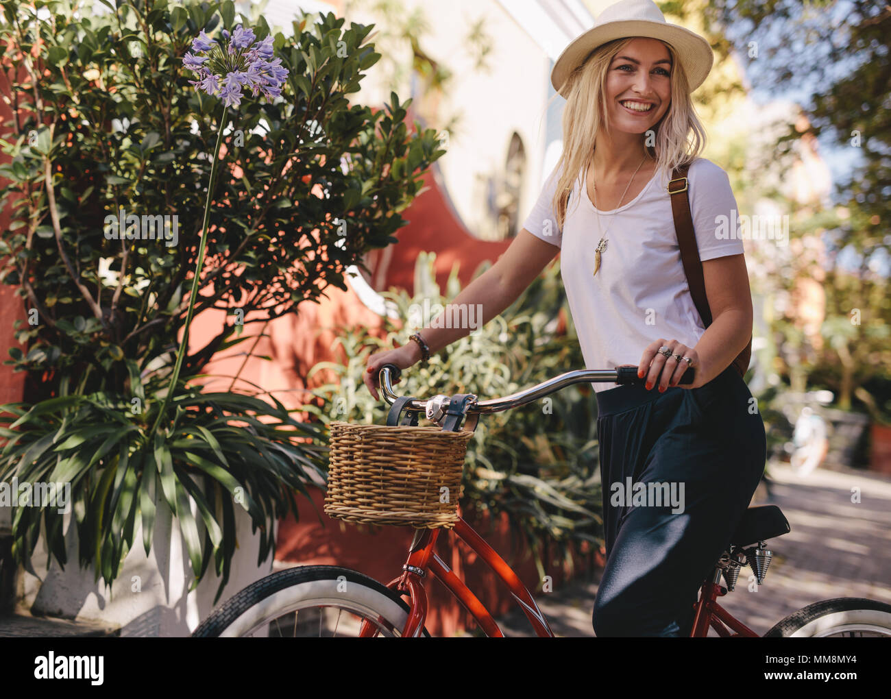 Bella donna con la sua bicicletta all'esterno. Femmina caucasica cavalcare la sua bici in città. Foto Stock
