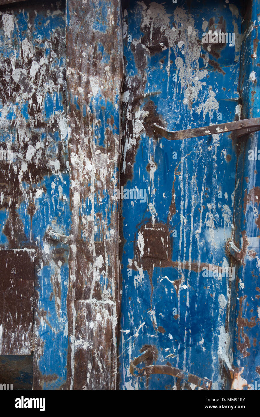 Un modello a trama di vernice bianca e marrone ruggine su un blu superficie di metallo Foto Stock