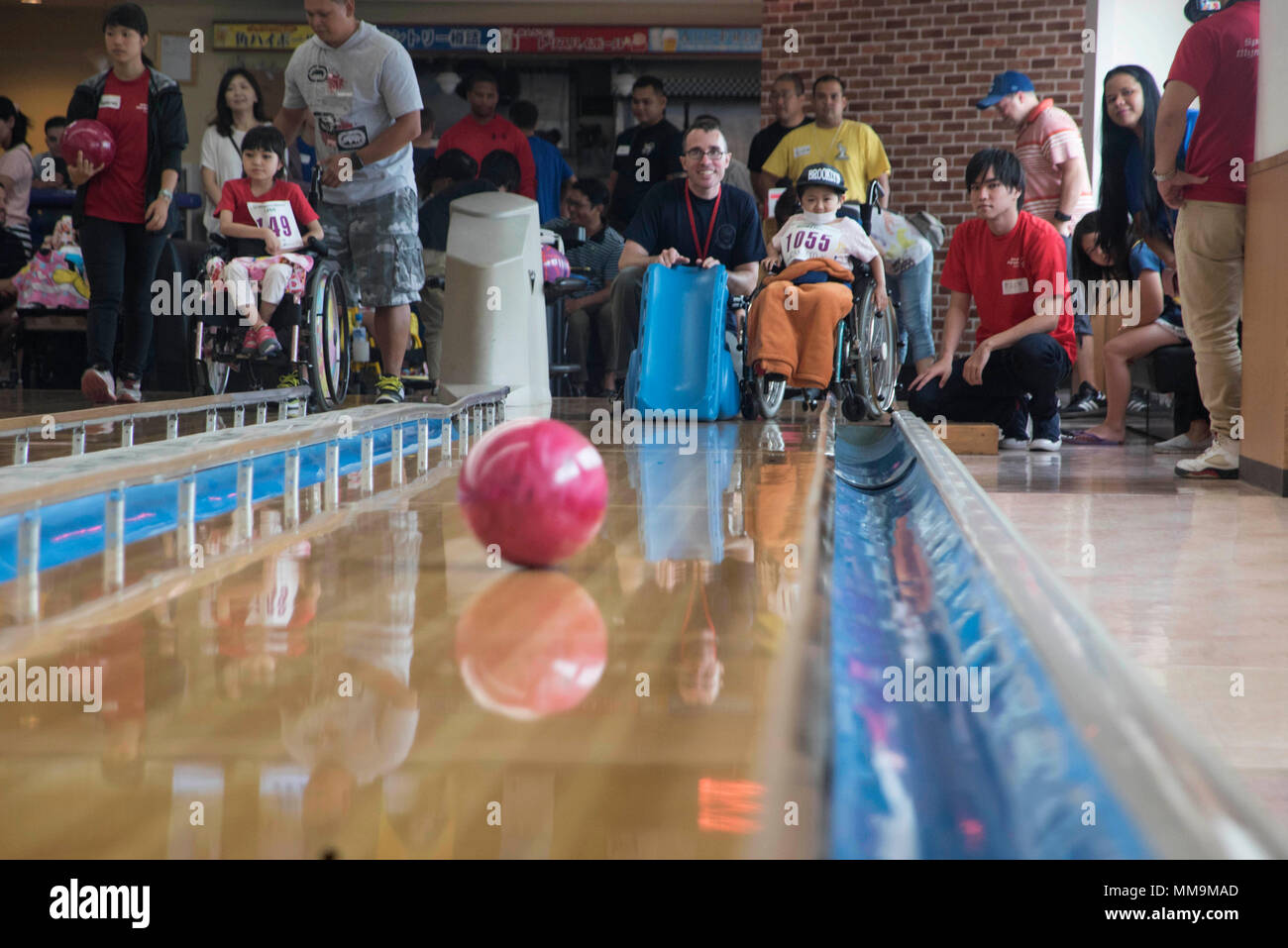 Hinata (centro), bowling partecipante, lavora con i volontari a rotolare una palla da bowling durante il XIII annuale di Kadena Special Olympics bowling concorrenza sett. 16, 2017, a Enagic ciotola, Okinawa. Membri del team di Kadena correva il bowling event per onorare e celebrare le esigenze speciali di individui in un divertente e sicuro e atmosfera favorevole. (U.S. Air Force foto/Senior Airman Quay Drawdy) Foto Stock