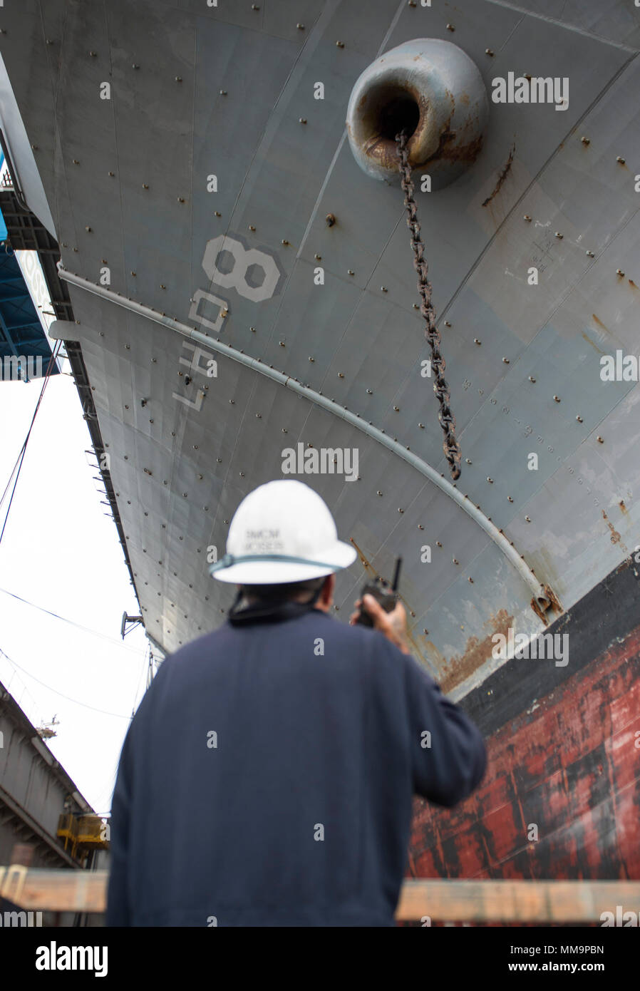 170921-N-LI768-1017 SAN DIEGO (sett. 21, 2017) Master Chief di Boatswain Mate Claus Moser comunica con i marinai nel castello di prua dell'assalto anfibio nave USS Makin Island (LHD 8) riducendo al contempo il carico di tribordo della catena di ancoraggio. Makin Island è attualmente in bacino di carenaggio di General Dynamics National la siderurgia e la costruzione navale Company (NASSCO) per un deposito di manutenzione di livello di disponibilità. (U.S. Foto di Marina di Massa lo specialista di comunicazione 2a classe Devin M. Langer) Foto Stock