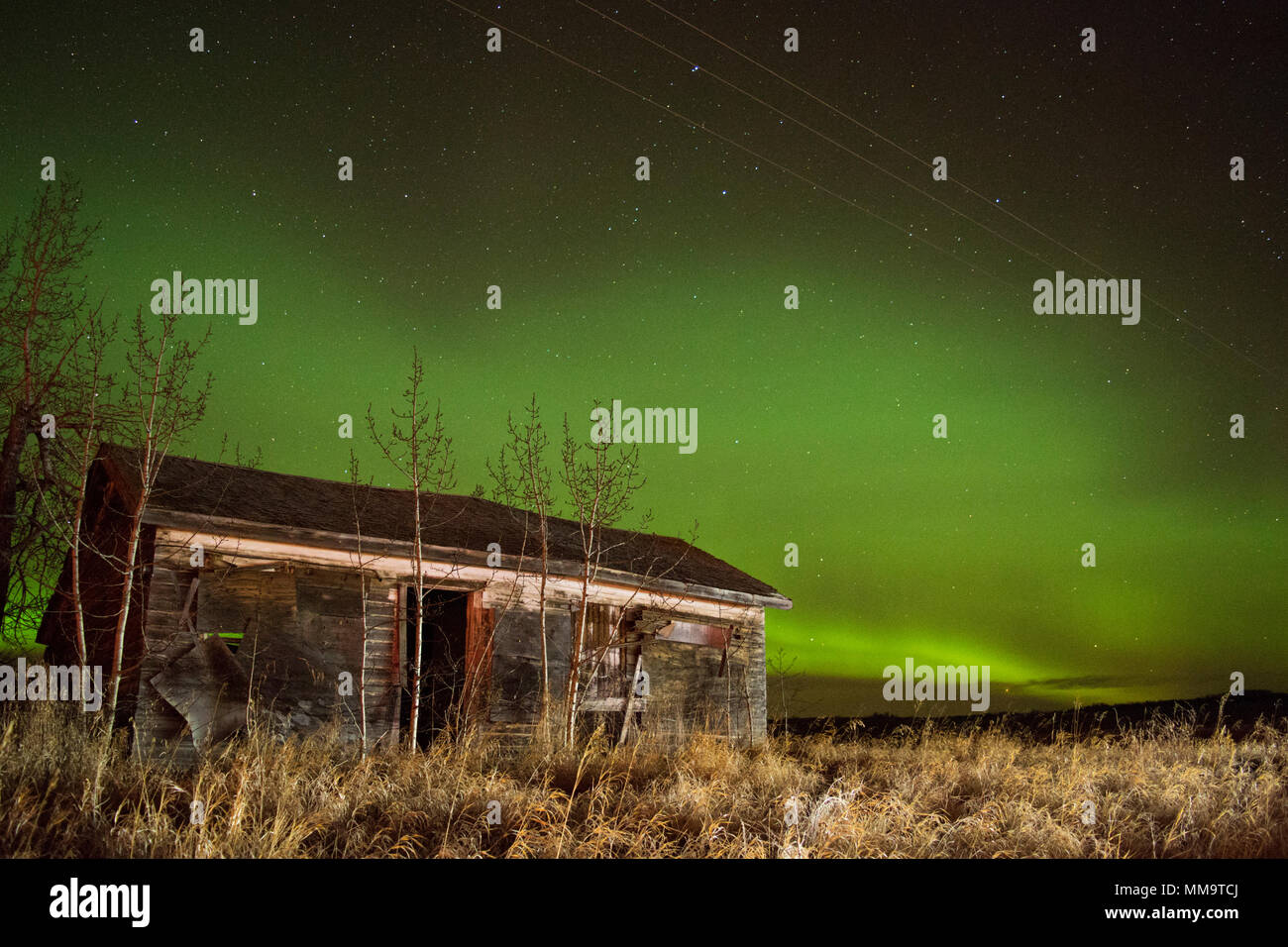 Northern Lights luce il cielo sopra una casa abbandonata in campagna Foto Stock