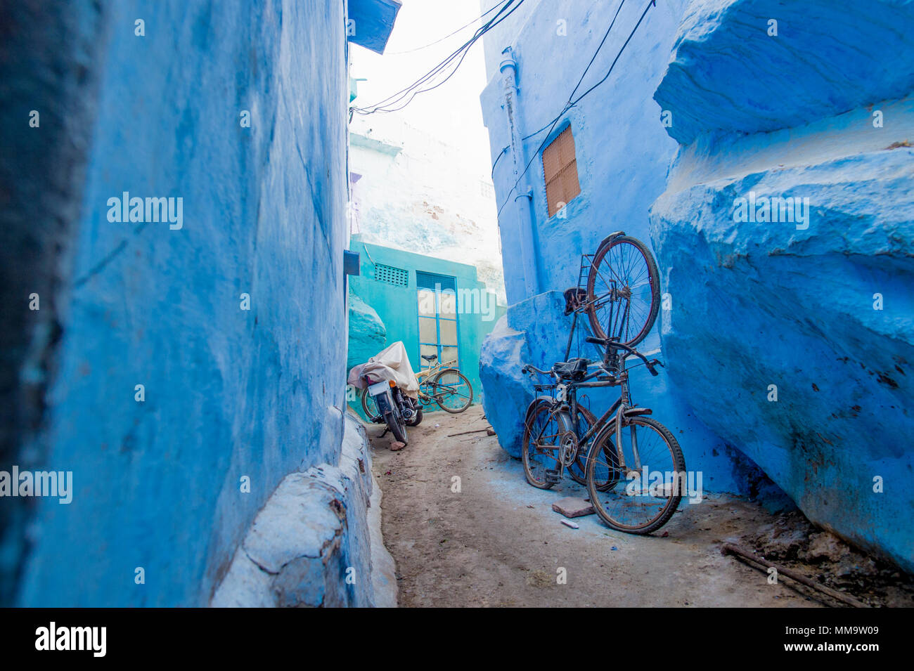 Una mountain bike e una moto in un piccolo vicolo nella città blu di Jodhpur, Rajasthan, India. Foto Stock