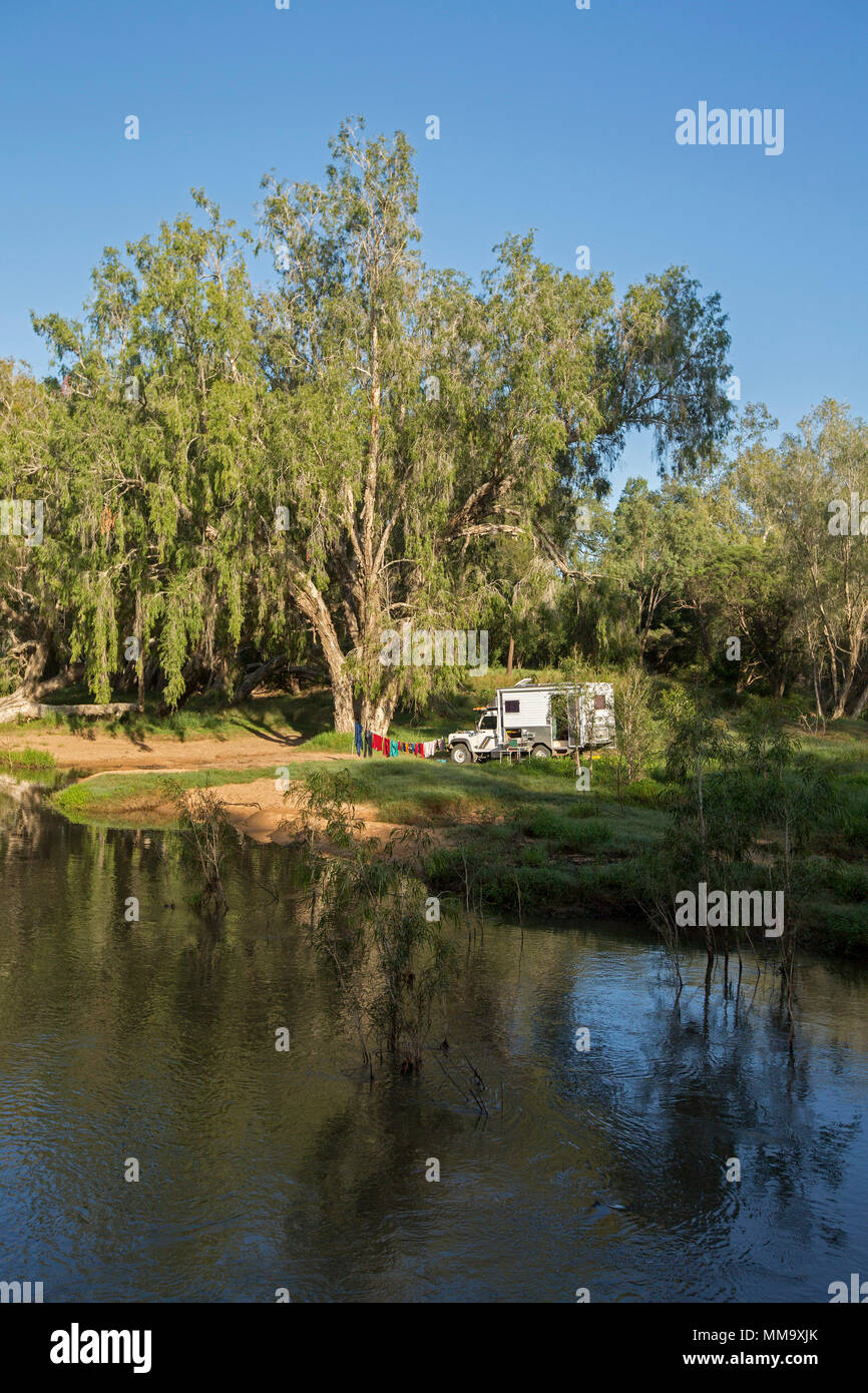 Veicolo per attività ricreative. Land Rover camper, in campeggio con splendide Australian foresta paesaggio & blue sky si riflette nelle calme acque del fiume Isacco Foto Stock