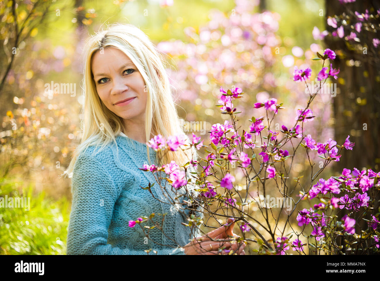Ritratto di giovane donna bella in primavera sbocciano i fiori rosmarino nella foresta Foto Stock