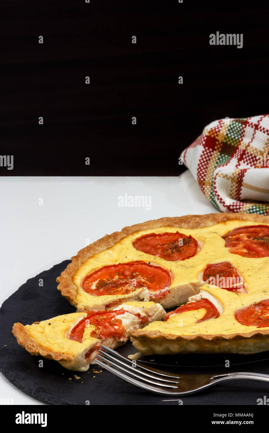 Vegetariani e pomodoro crostata di ricotta e wineglass di bianco vino di uve su sfondo scuro e luce. Close up. Messa a fuoco selettiva. Foto Piazza. Spazio di copia Foto Stock