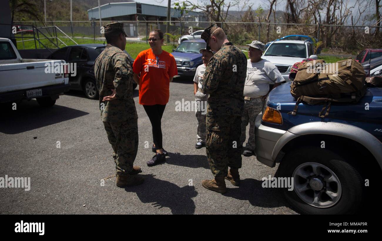 Stati Uniti Marines e marinai con la ventiseiesima Marine Expeditionary Unit (MEU) parlare di volontari locali circa le esigenze del locale centro di distribuzione e il loro processo sistematico di distribuzione degli aiuti in Yabucoa, Puerto Rico, Ottobre 3, 2017. Il ventiseiesimo MEU è il supporto di Federal Emergency Management Agency, il piombo agenzia federale, per aiutare le persone colpite dall'uragano Maria per ridurre al minimo la sofferenza ed è un componente del complessivo intero-di-risposta del governo sforzo. (U.S. Marine Corps foto di Cpl. Juan A. Soto-Delgado) Foto Stock