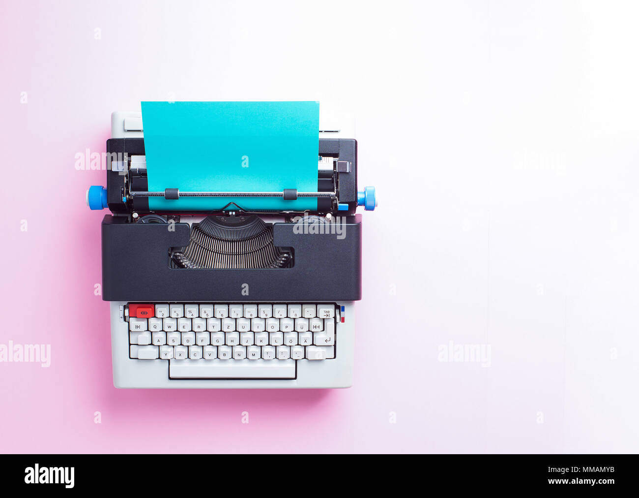 Nastri inchiostratori per macchine da scrivere con carta blu su sfondo rosa, vista dall'alto Foto Stock