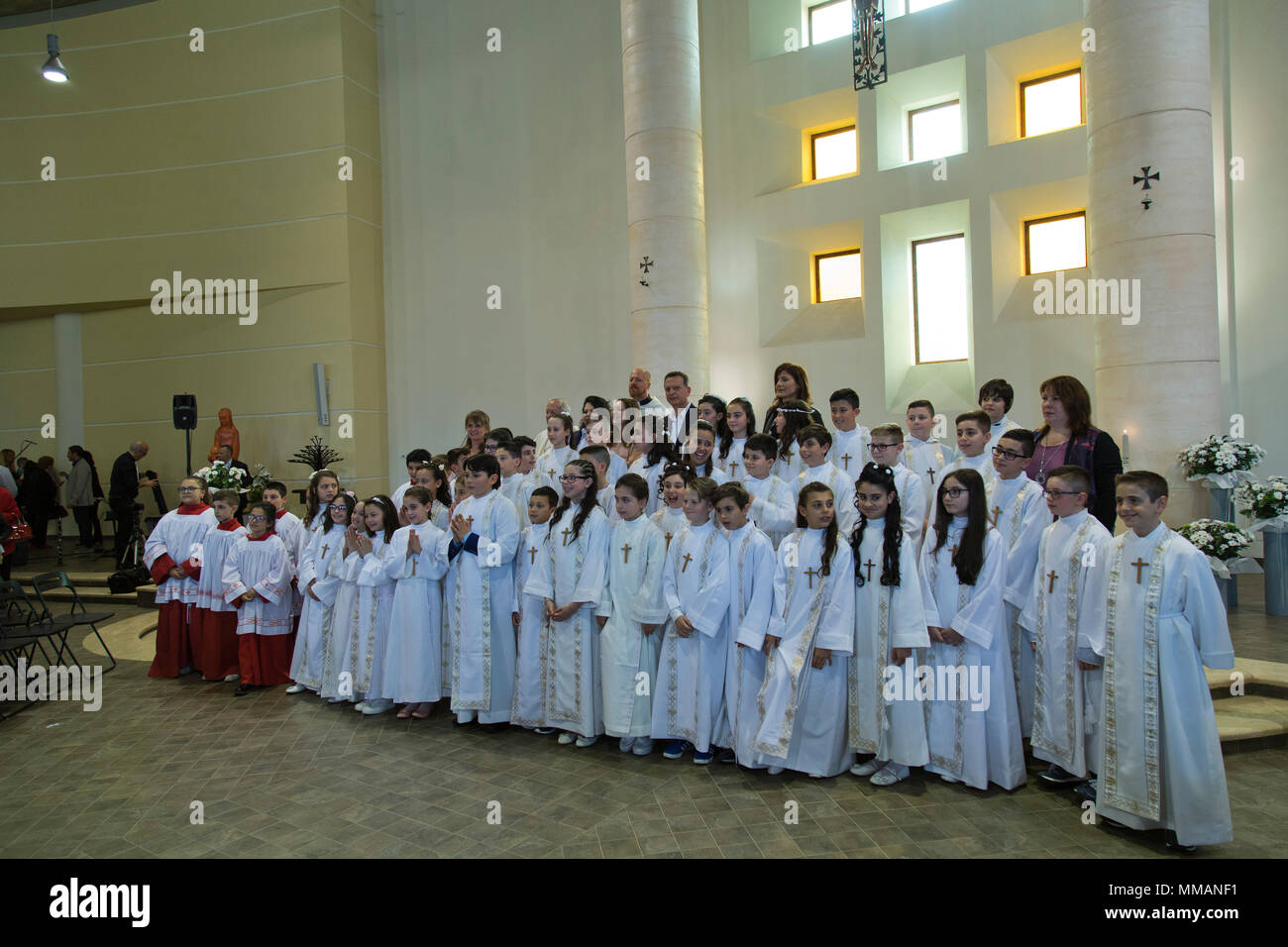 Sacerdote conduce la processione dei bambini circa per avere la loro prima Comunione in Bracciano Italia Foto Stock