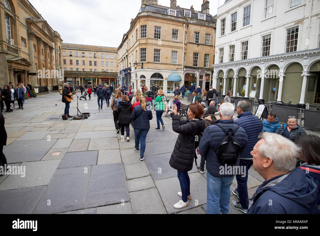 I turisti in visita a piedi della vasca da bagno a piedi attraverso il sagrato Abbazia di Bath England Regno Unito Foto Stock