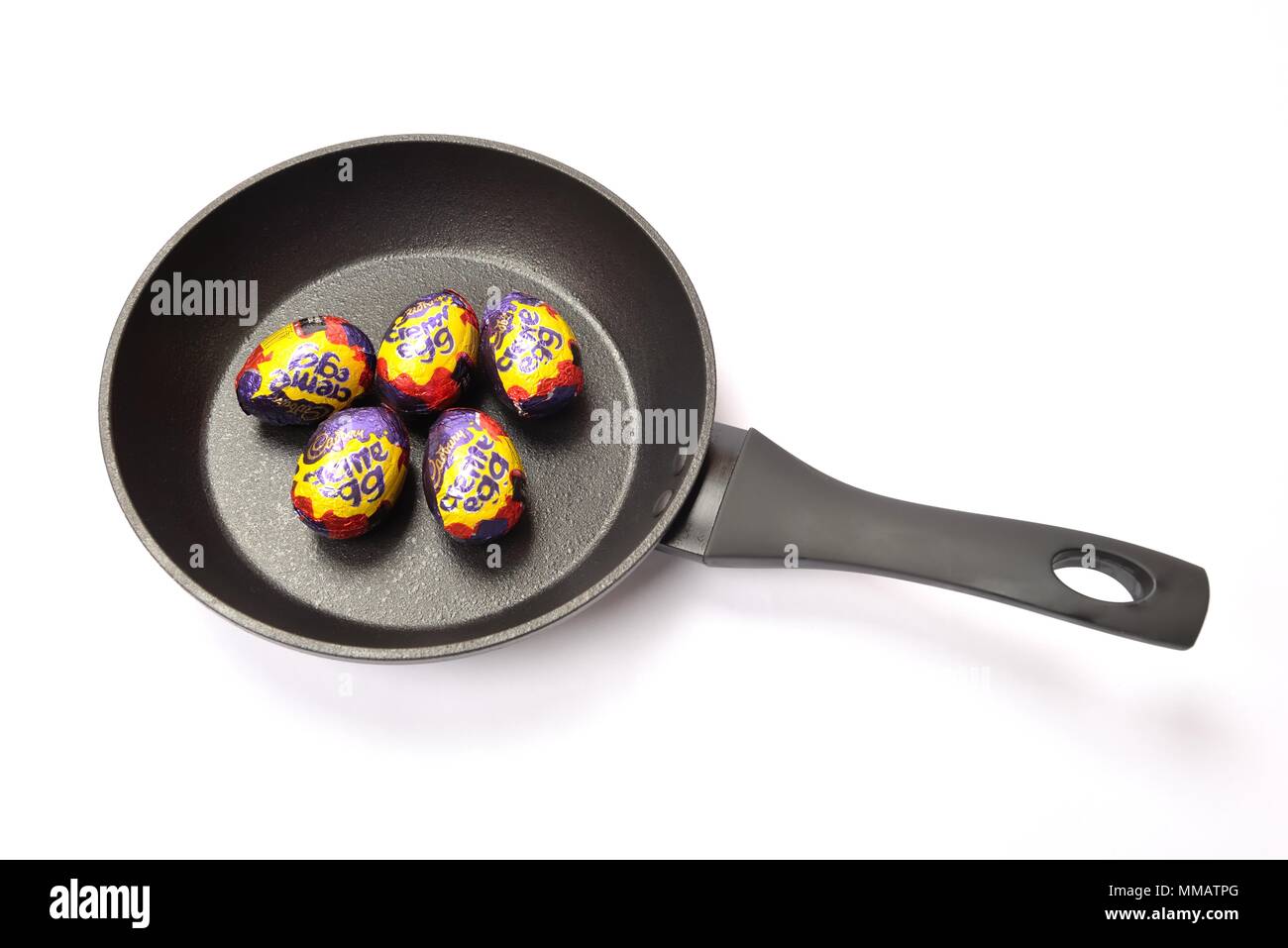 Concetto di immagine di cinque Cadbury's crema di uova in una padella su sfondo bianco. Foto Stock